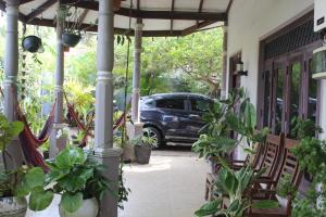 a car is parked on a porch with plants at surfing lion villa kudawella in Mawella +6 photos
