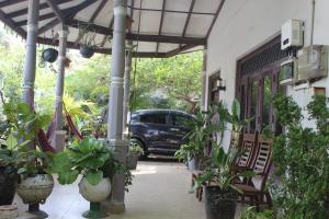 a porch with potted plants and a car parked at surfing lion villa kudawella in Mawella