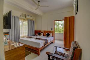 a bedroom with a bed and a large window at Atithi Comforts in Kushālnagar