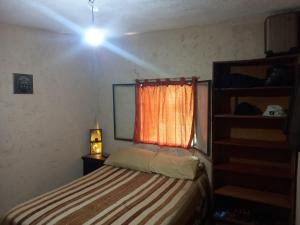 a small bedroom with a bed and a window at El PRADO in Alta Gracia