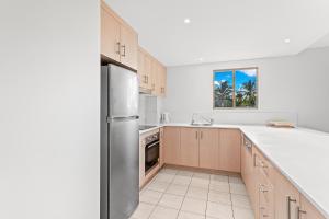 a kitchen with a stainless steel refrigerator and a window at The Crabpot in Airlie Beach +5 photos