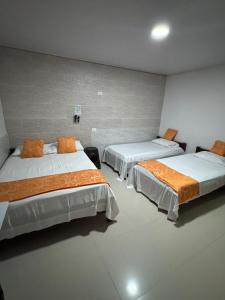 a room with two beds in a room at Hotel Beraka in Fortul
