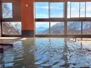 a swimming pool with a view of a mountain at 秘湯花文 in Myoko