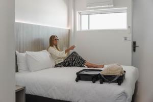 a woman sitting on a bed in a room at The Royal Casino in Casino +11 photos