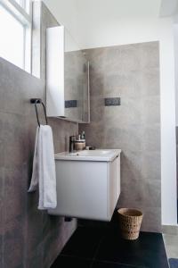 a bathroom with a white sink and a mirror at Rockvin BnB in Midigama East