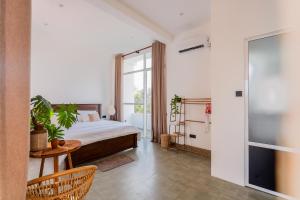 a bedroom with a bed and a table and a window at Rockvin BnB in Midigama East