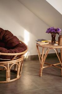 a chair and a table with a vase of purple flowers at Rockvin BnB in Midigama East