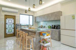 a kitchen with a counter with chairs and a refrigerator at Xin Young Villa in Zhuangwei