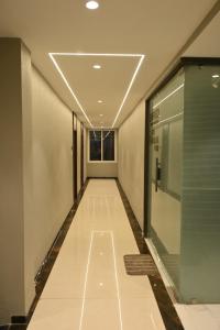 an empty corridor in a building with a window at Hotel Abhilasha Premium in Dewās