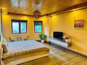 a bedroom with a large bed and a flat screen tv at Ultra View Homestay in Sapa