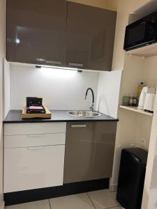 a kitchen with white cabinets and a sink at Prana Lodge Saint Gilles les Bains 800 m de la plage in Saint-Gilles-les-Bains +20 photos