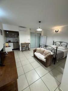 a living room with a bed and a couch at Prana Lodge Saint Gilles les Bains 800 m de la plage in Saint-Gilles-les-Bains