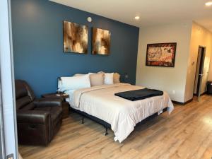 a bedroom with a bed and a leather chair at Airstay LLC in Clark