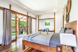 a bedroom with a bed and a large window at Orora Bungalows Batu Bolong Canggu in Canggu +27 photos