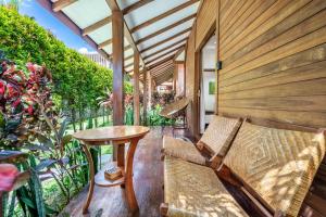 a porch with a bench and a table and some plants at Orora Bungalows Batu Bolong Canggu in Canggu