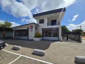 a white house with a car parked in front of it at Lobby Apartments in Paramaribo