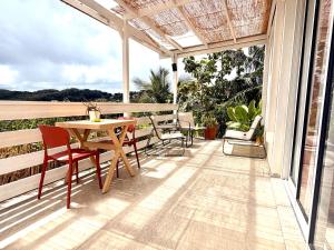 a patio with a table and chairs on a balcony at Appartement spacieux La Vanille 2 in Ducos