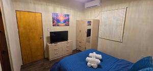 a bedroom with a blue bed and a television at Cozy Hub -B in Philipsburg