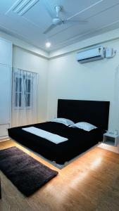 a bedroom with a large black bed in a room at Satkarma in Rishīkesh