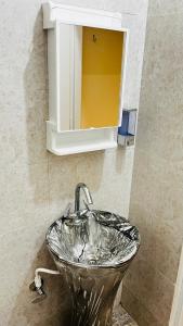 a sink in a bathroom with a mirror at Satkarma in Rishīkesh