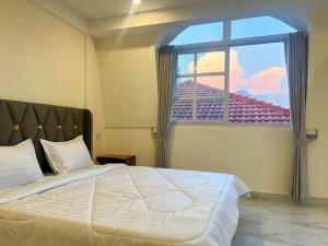 a bedroom with a large bed and a window at A Z Hotel Phnom Penh in Phnom Penh