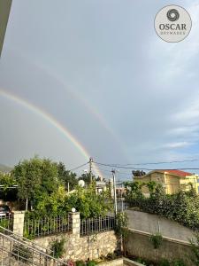 a rainbow in the sky over a city at Oscar’s Apartments Drymades in Dhërmi