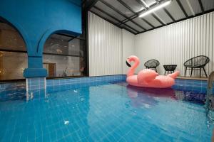 a pool with two pink flamingos in the water at Gapyeong T Pension in Gapyeong