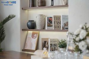a book shelf with books and vases on it at Santorini Homestay Phan Thiet in Tiến Thành