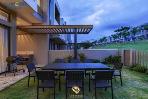 a patio with a table and chairs and a grill at Santorini Homestay Phan Thiet in Tiến Thành