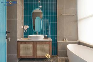 a bathroom with a sink and a tub and a mirror at Santorini Homestay Phan Thiet in Tiến Thành +19 photos