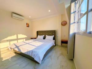 a bedroom with a bed and a large window at A Z Hotel Phnom Penh in Phnom Penh