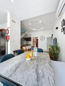 a dining room with a table with oranges on it at Modern Duplex Apartment with Private Pool & AC Central Malta in Balzan