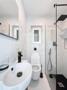a white bathroom with a sink and a toilet at Modern Duplex Apartment with Private Pool & AC Central Malta in Balzan +34 photos