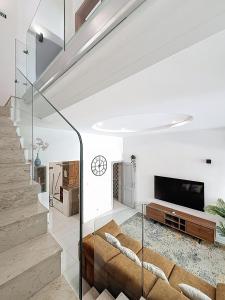 a large living room with a couch and a tv at Modern Duplex Apartment with Private Pool & AC Central Malta in Balzan