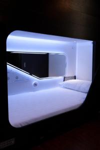 a white bed in a room with a mirror at Auckland Boutique Capsule in Auckland