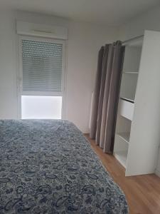 a bedroom with a bed and a window at Gite des Capucines in Bourbourg