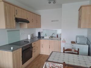 a kitchen with wooden cabinets and a counter top at Gite des Capucines in Bourbourg