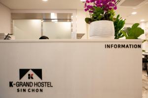 a counter with a vase of flowers on top of it at K-Grand Hostel Sinchon in Seoul