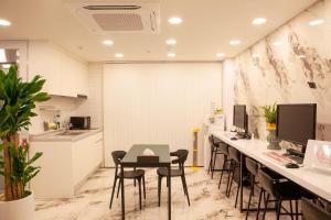 an office with a table and chairs and a kitchen at K-Grand Hostel Sinchon in Seoul