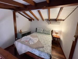 a bedroom with a bed in a room with wooden ceilings at Studio Hashi 04 in Paraty