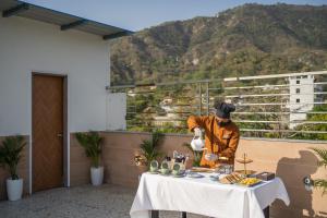 a chef preparing food on a table on a balcony at Perfectstayz Premium Dehradun at Rajpur road in Dehradun