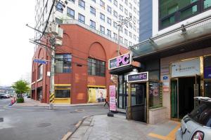 a city street with buildings and a pay phone at K-Grand Hostel Sinchon in Seoul