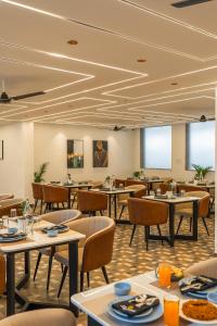 a dining room filled with tables and chairs at Perfectstayz Premium Aurevva, Rajpur road in Rājpur