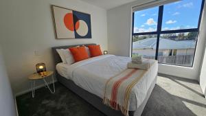 a bedroom with a bed and a large window at 20 Te Kanawa Haven in Auckland