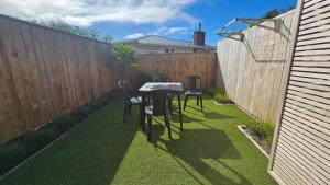 a small backyard with a table and chairs and a fence at 20 Te Kanawa Haven in Auckland
