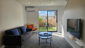a living room with a couch and a table at 20 Te Kanawa Haven in Auckland