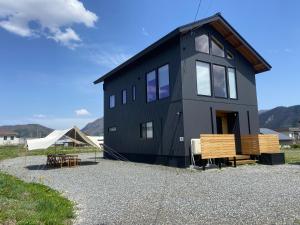 a black house sitting on top of a gravel lot at White Sierra Chalet in Hakuba