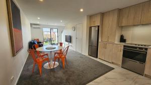 a kitchen with a table and chairs in a room at 20 Te Kanawa Haven in Auckland
