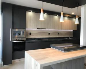 a kitchen with black cabinets and a wooden counter top at Casaaurea in Jesús María