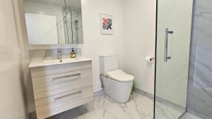 a bathroom with a toilet and a sink and a shower at 20 Te Kanawa Haven in Auckland +2 photos